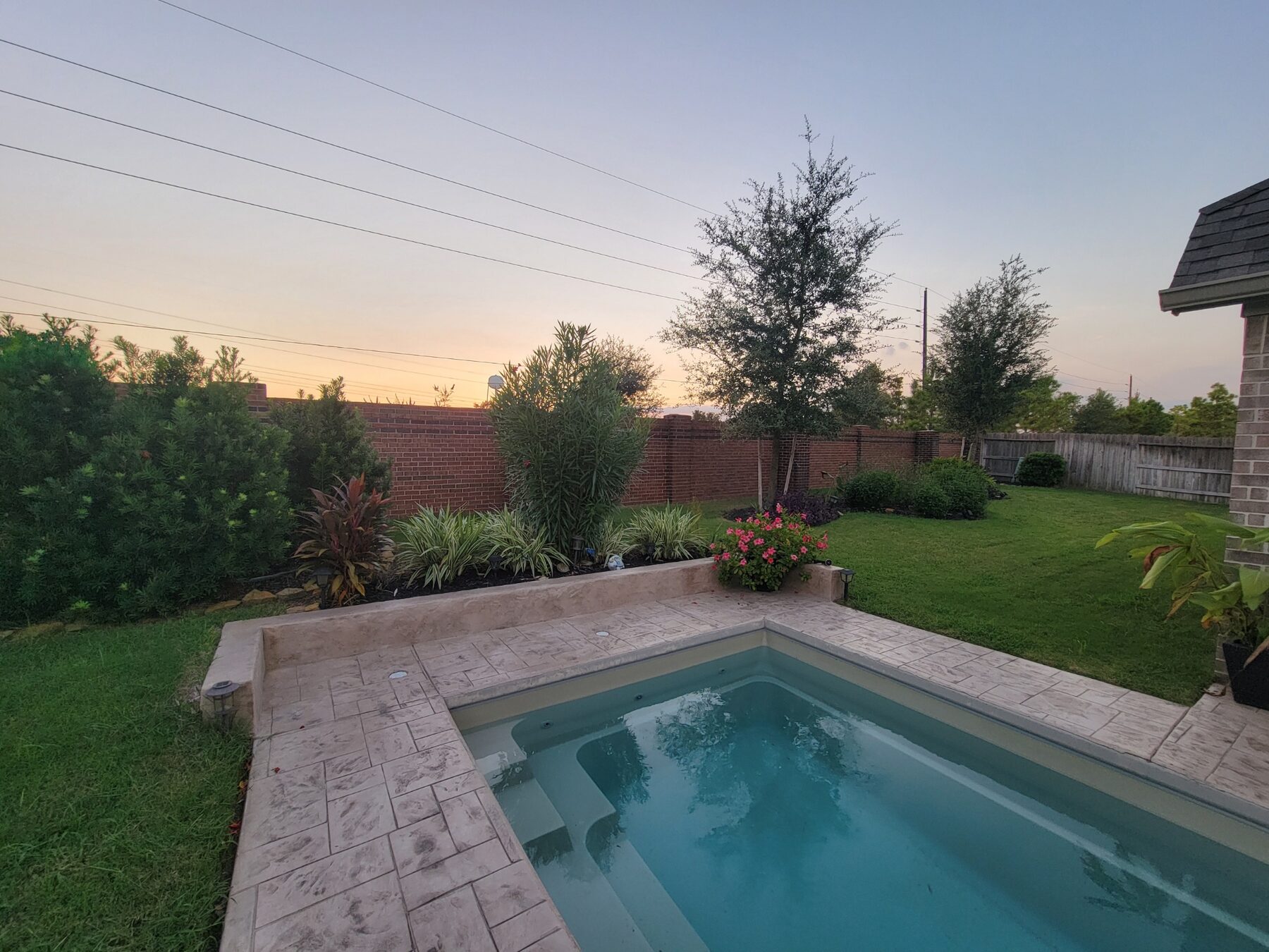 Completed pool installation in Houston, Texas — sunset view of finished backyard