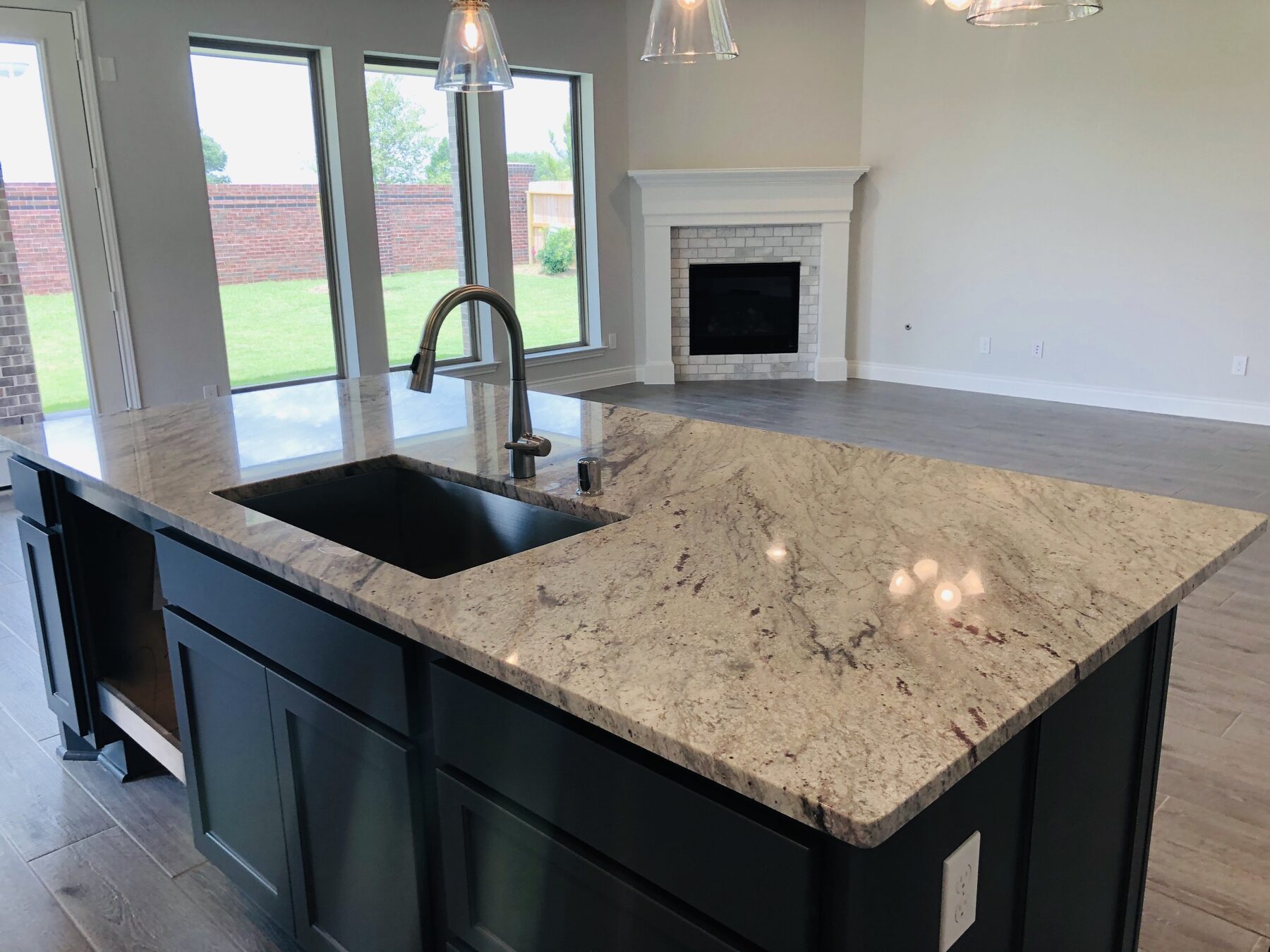 Open kitchen with granite island and corner fireplace