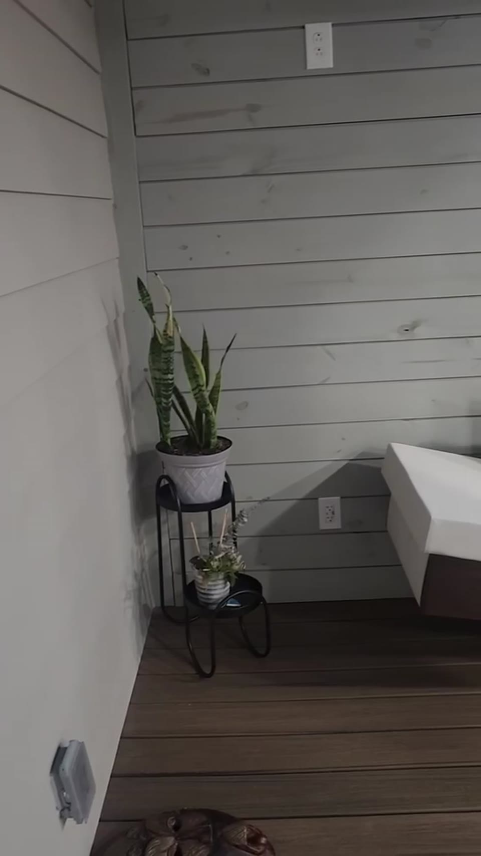 Finished outdoor living space with gray shiplap walls and bench seating